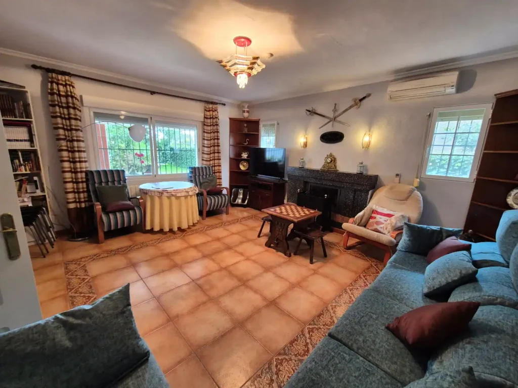 Salón acogedor con chimenea encendida en alojamiento rural de Toledo.